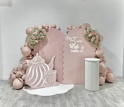 Birthday decor in Leicester by Lulu Belle Events. Tea for Two tea party. Dusty pink, mauve, and white. Organic balloon garland framing both backdrop panels in an arch formation. Dusty pink and nude/blush tones in mixed sizes.