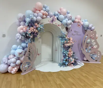 Birthday decor in Derby by Lulu Belle Events. Butterfly / royal fairy-tale. Pastel pink, baby blue, lilac and mauve. Organic balloon garland running across the top and down both sides of the arch structure to floor level. Pastel pink, baby blue, lilac and mauve in a mix of sizes.