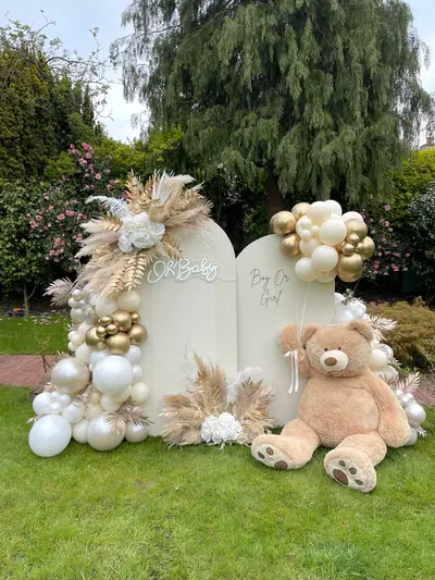 Baby shower decor in Leicester by Lulu Belle Events. Outdoor garden on natural grass lawn. Boho / neutral gender reveal. Cream, ivory, white, champagne, chrome gold, natural pampas tones. Double arch, two adjoining arch-topped panels.